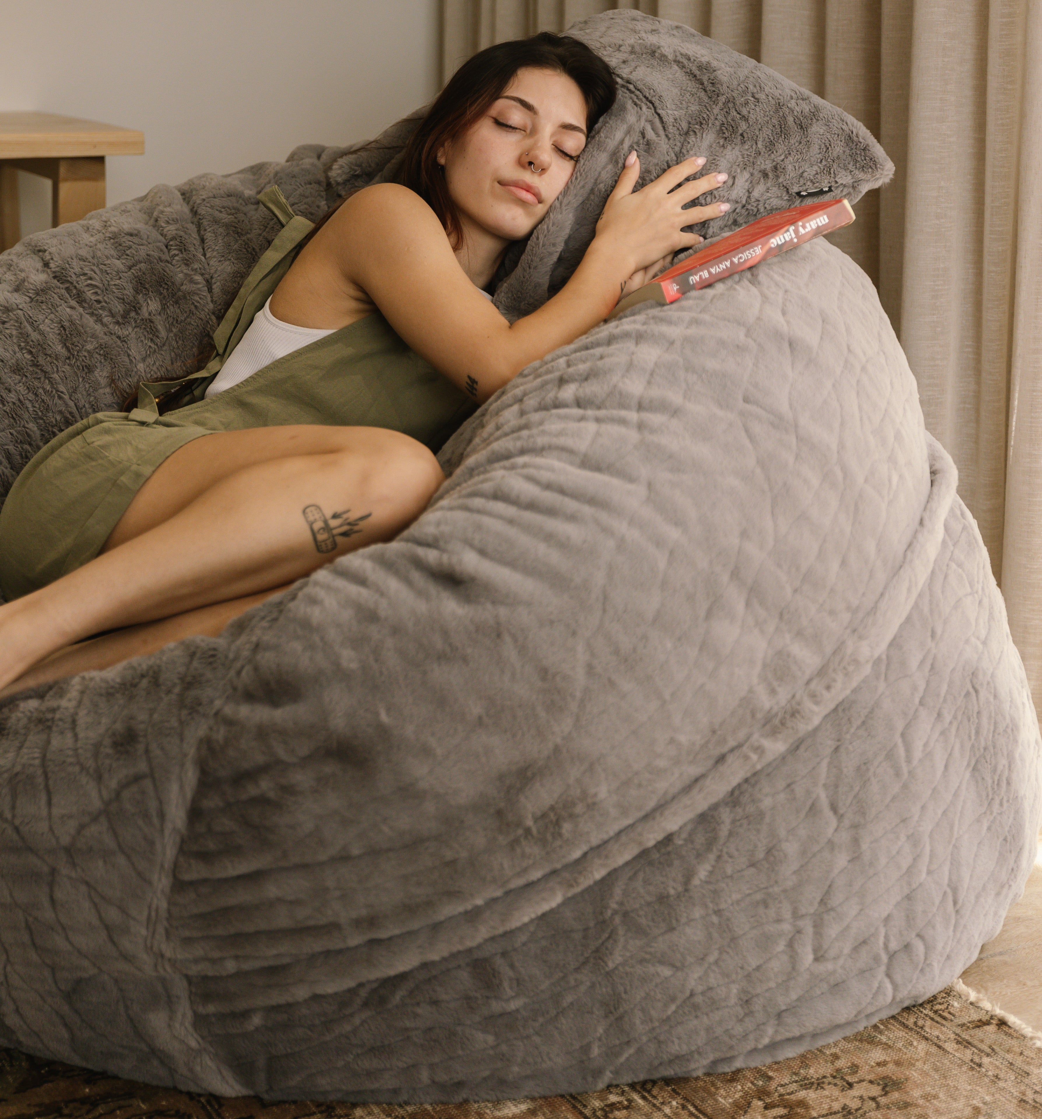Woman sleeping on large faux fur beanbag