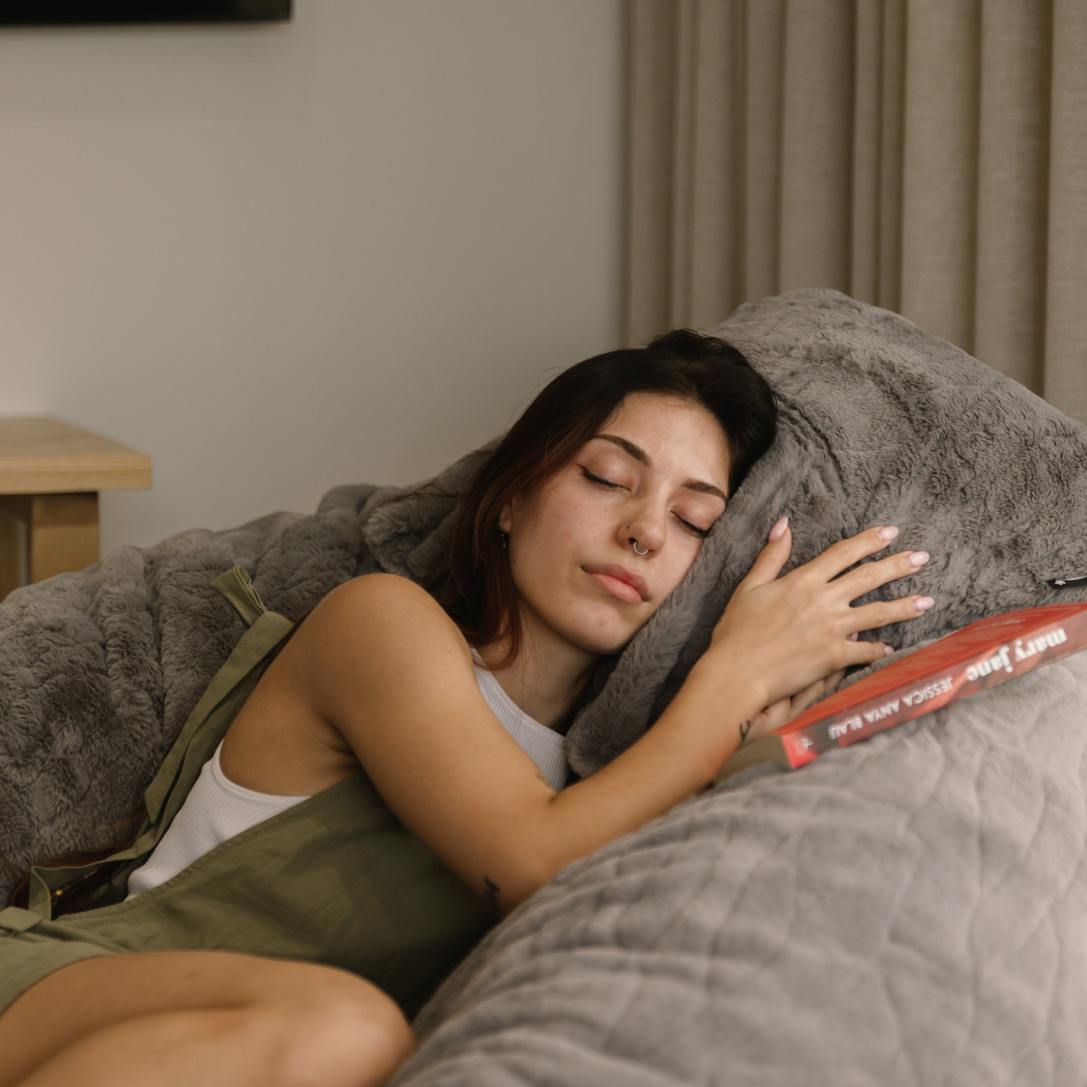 Woman sleeping on large faux fur beanbag