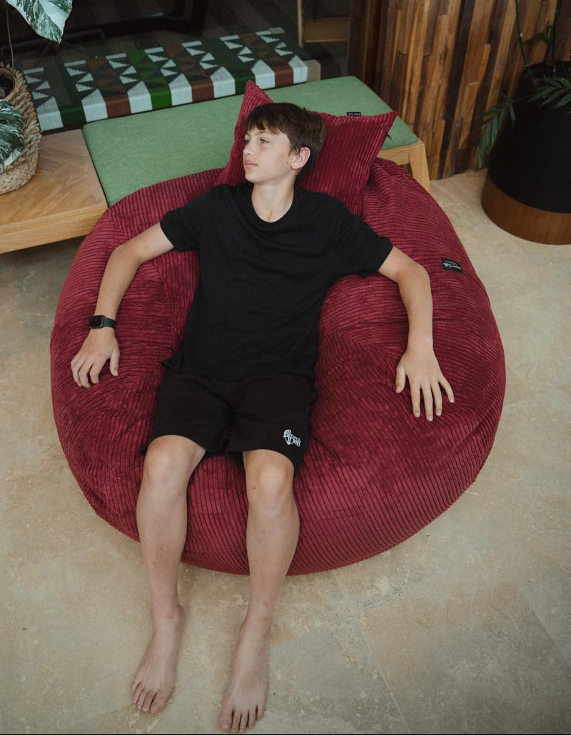 Person sitting on a red bean bag chair in a casual setting