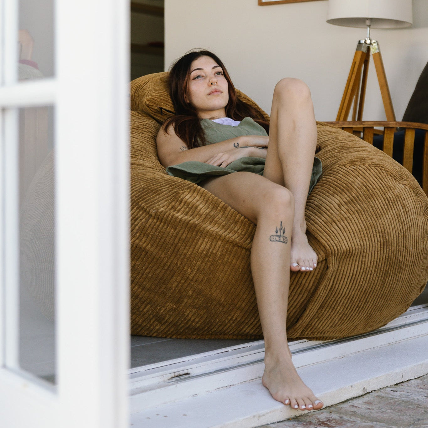 Woman sitting on light brown beanbag