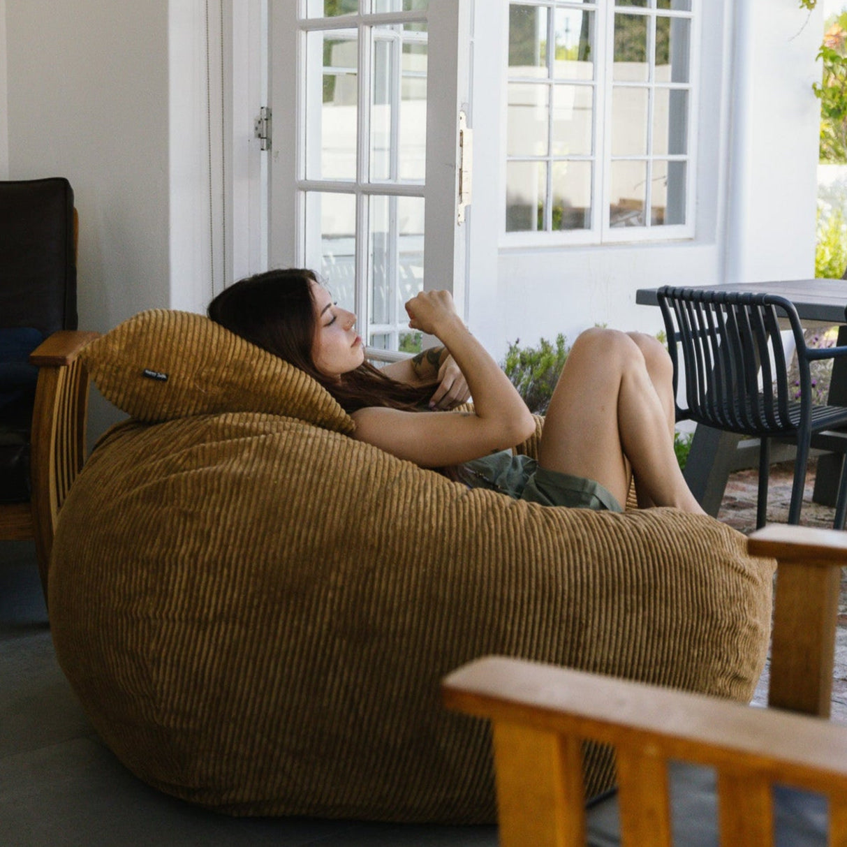 Woman relaxing on light brown beanbag