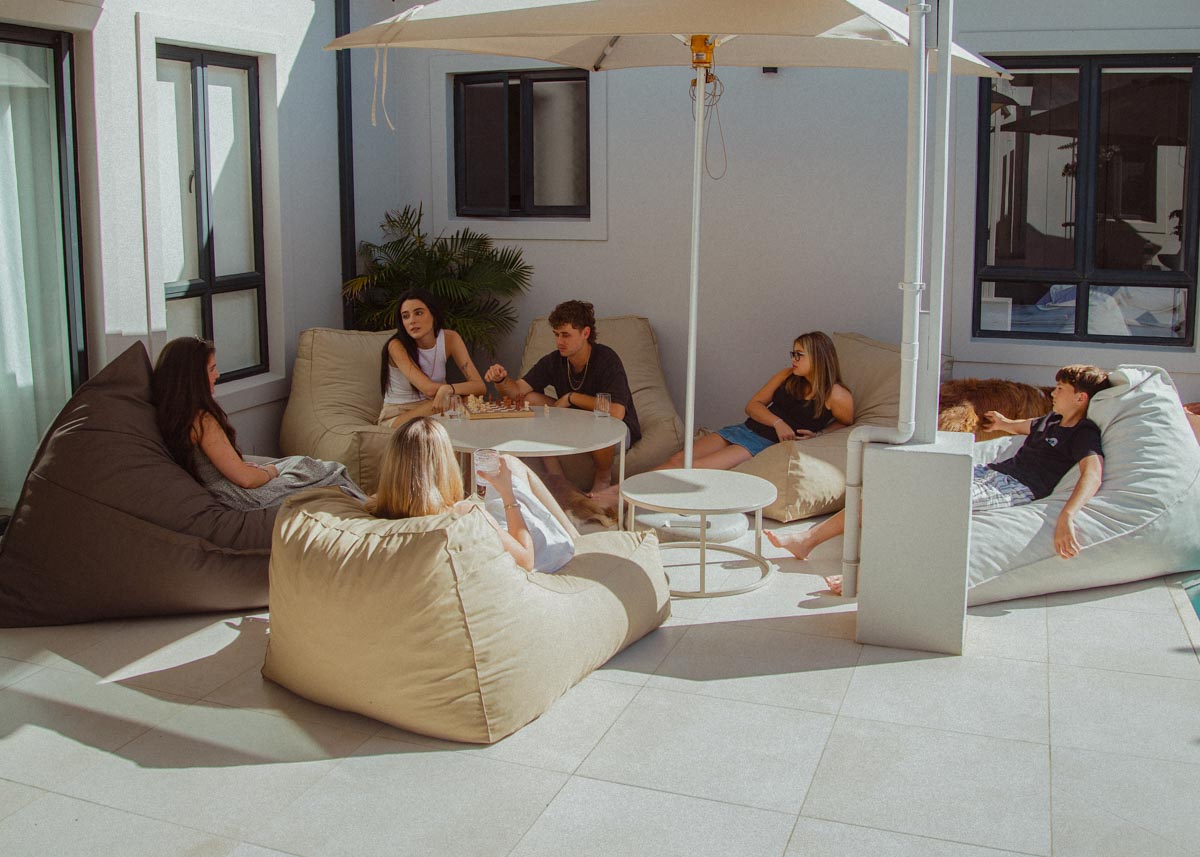 Group of people relaxing on outdoor furniture under an umbrella