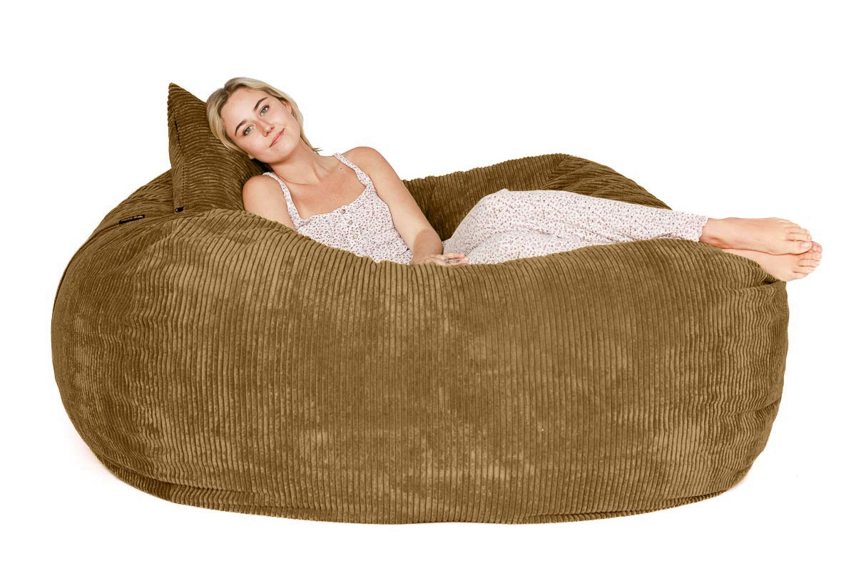 Woman lying on a large brown bean bag chair against a white background