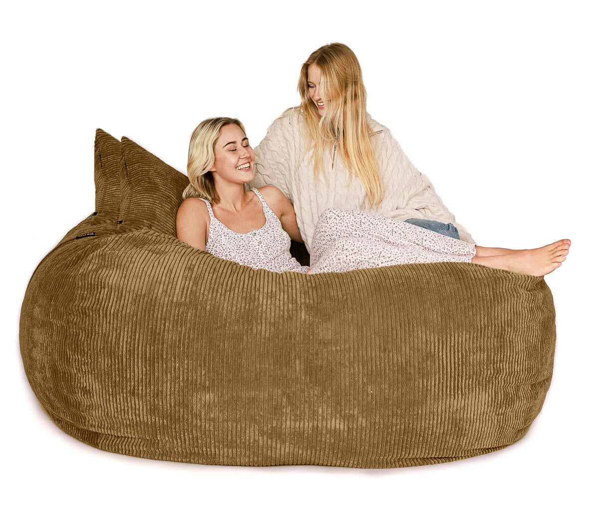 Two women sitting on a large brown bean bag chair against a white background