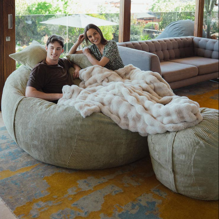 Two people relaxing on bean bags in a modern living room.