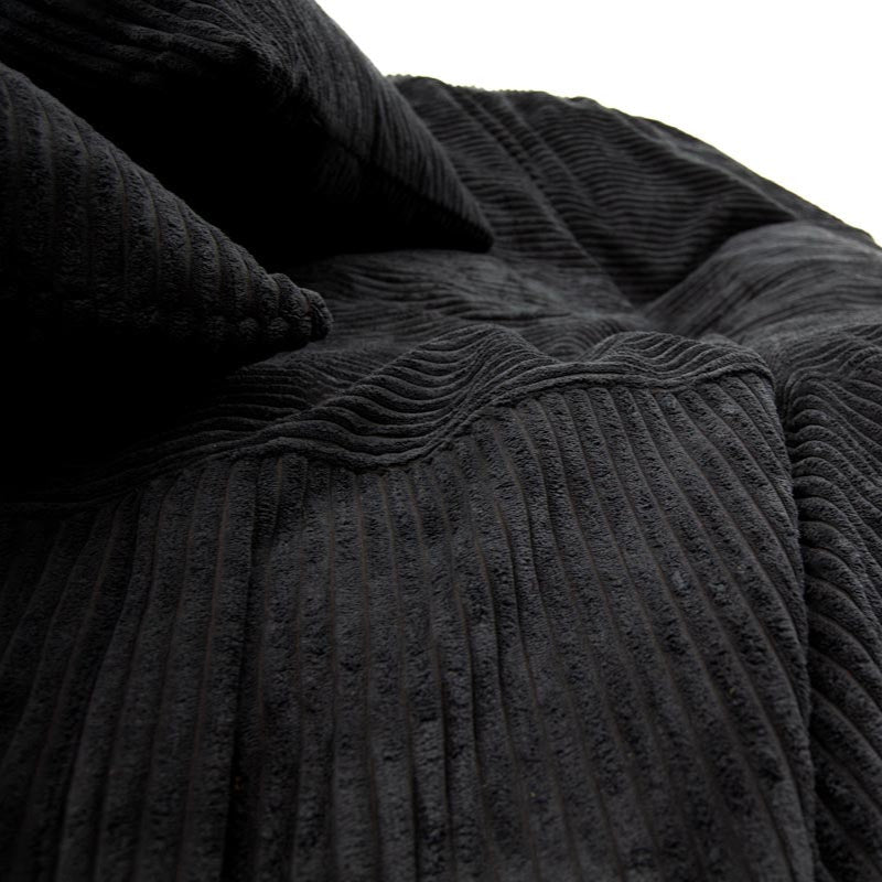 Close-up of a textured black blanket and pillow