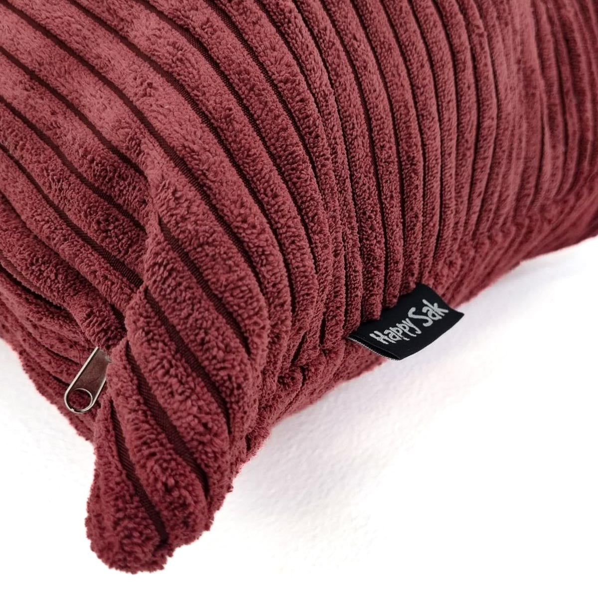 Red textured pillow with a brand tag on a white background