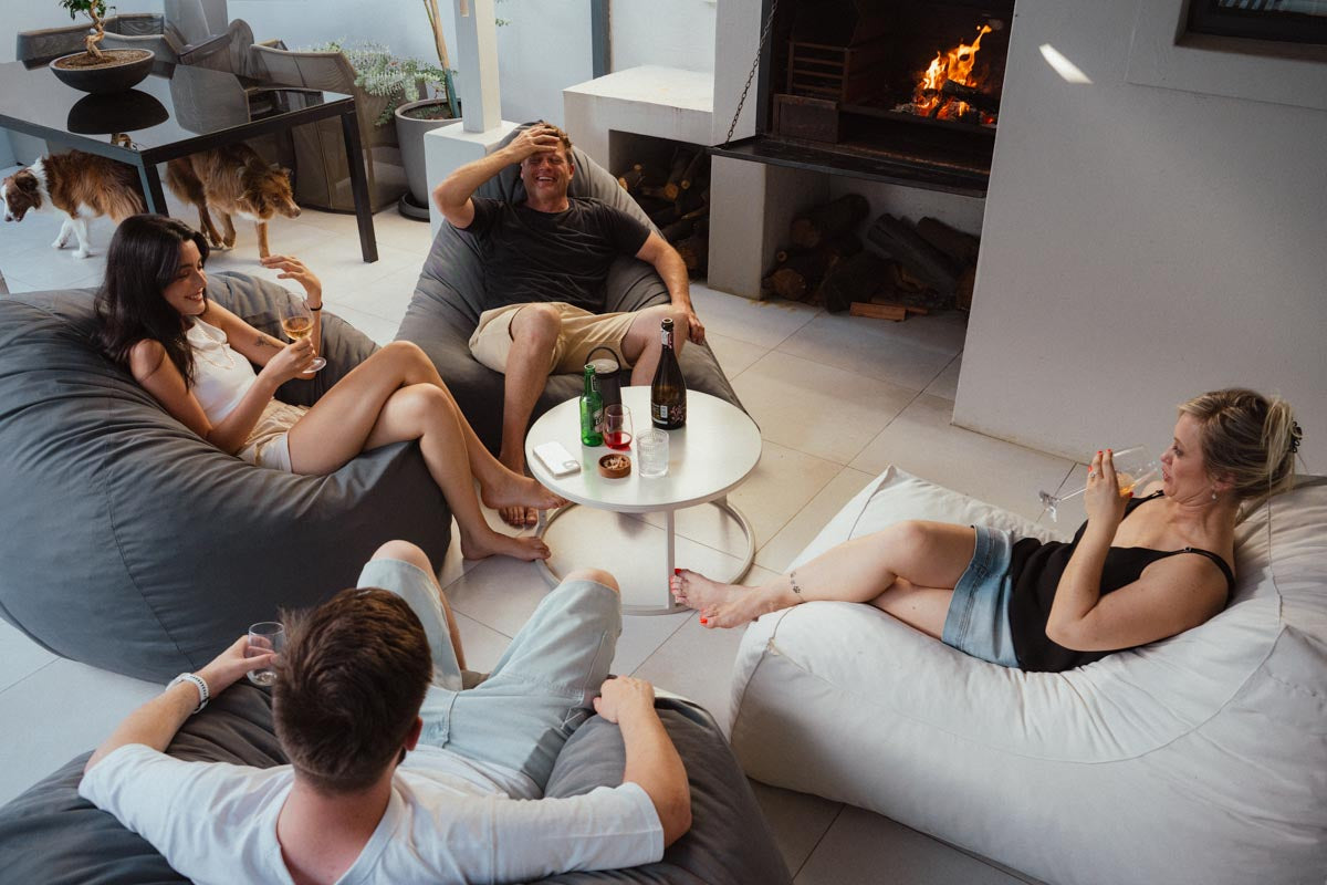 People relaxing on bean bags in a modern living room with a fireplace.