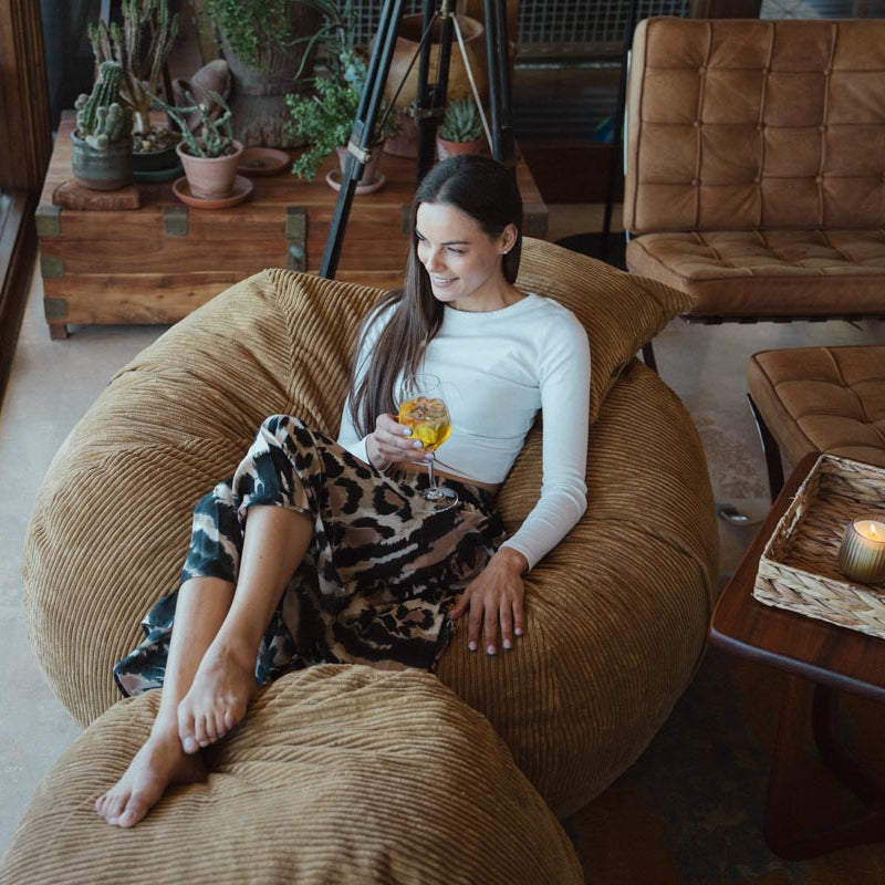 Woman sitting on a bean bag chair in a cozy living room.