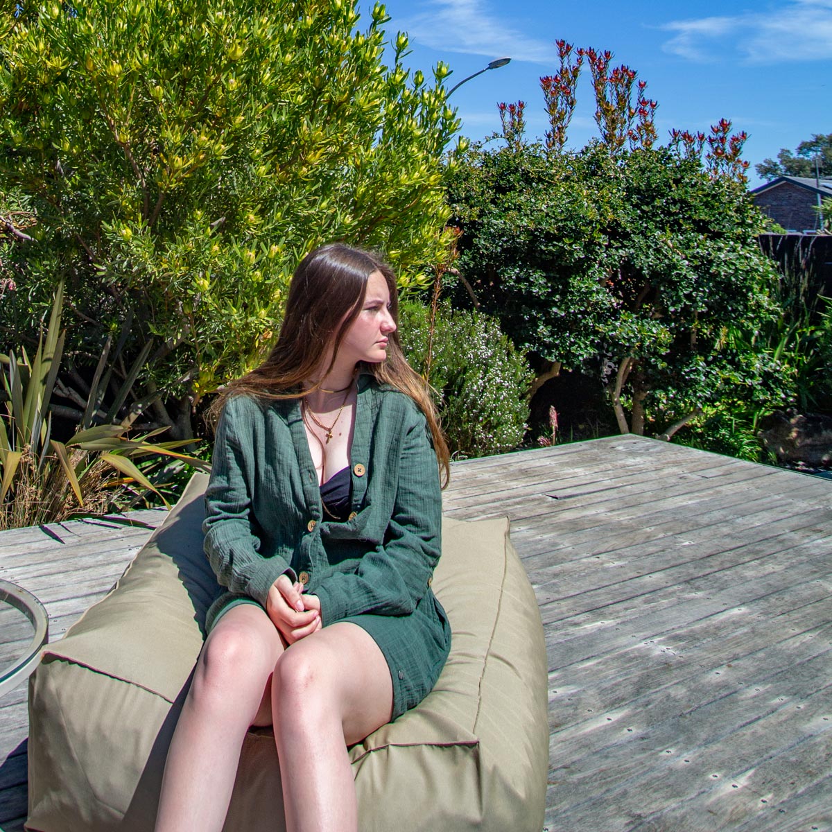 Woman sitting on a bean bag chair in a garden setting