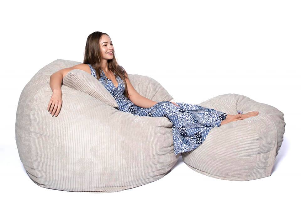 person sitting on large cream bean bag