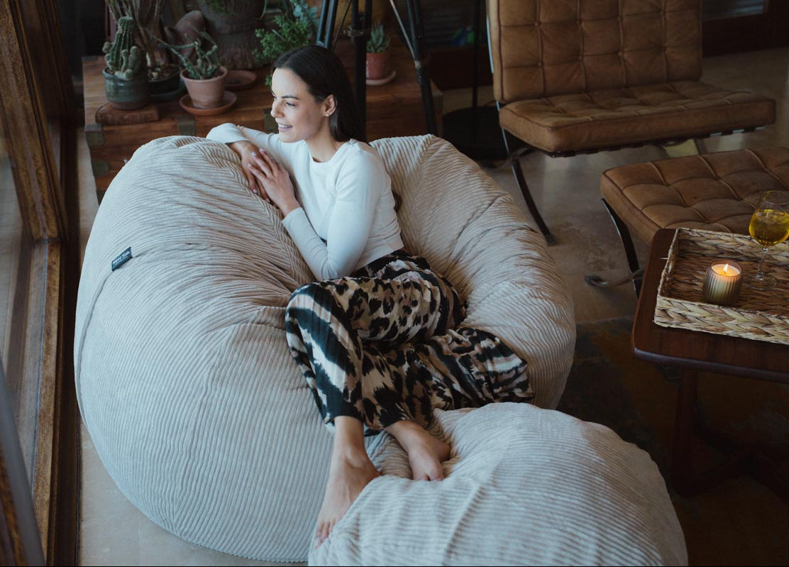 Woman sitting on a bean bag chair in a cozy living room.