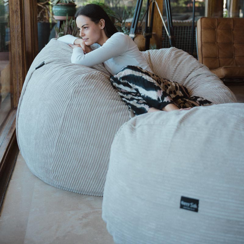 Woman relaxing on a bean bag chair in a modern indoor setting