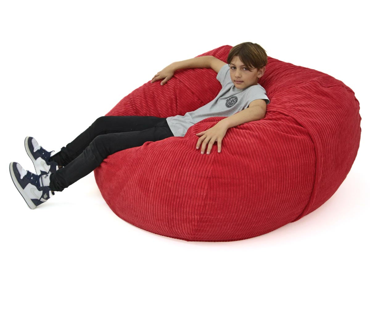 Person sitting on a large red bean bag chair against a white background