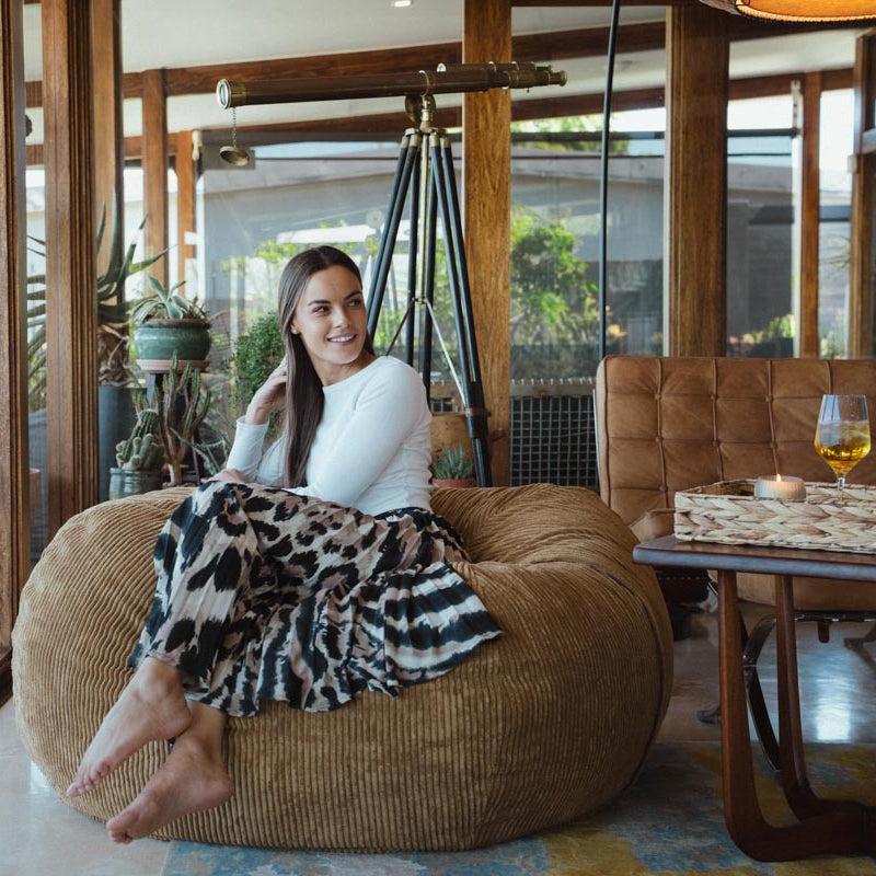 Woman sitting on a bean bag chair in a modern living room.