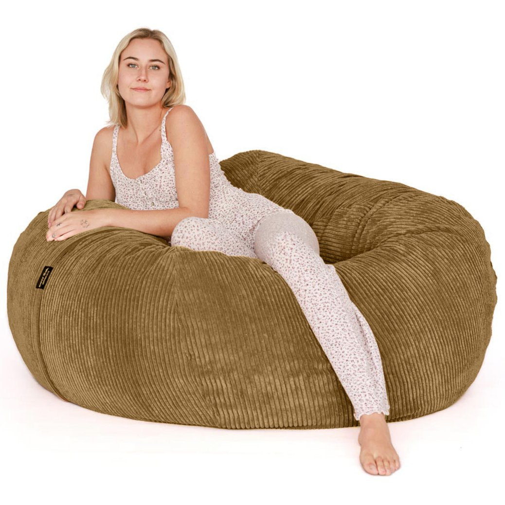 Woman sitting on light brown beanbag