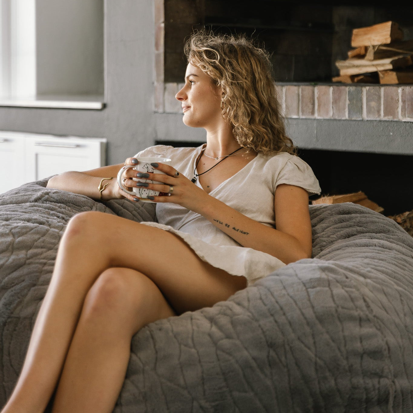woman sitting on light grey fur beanbag