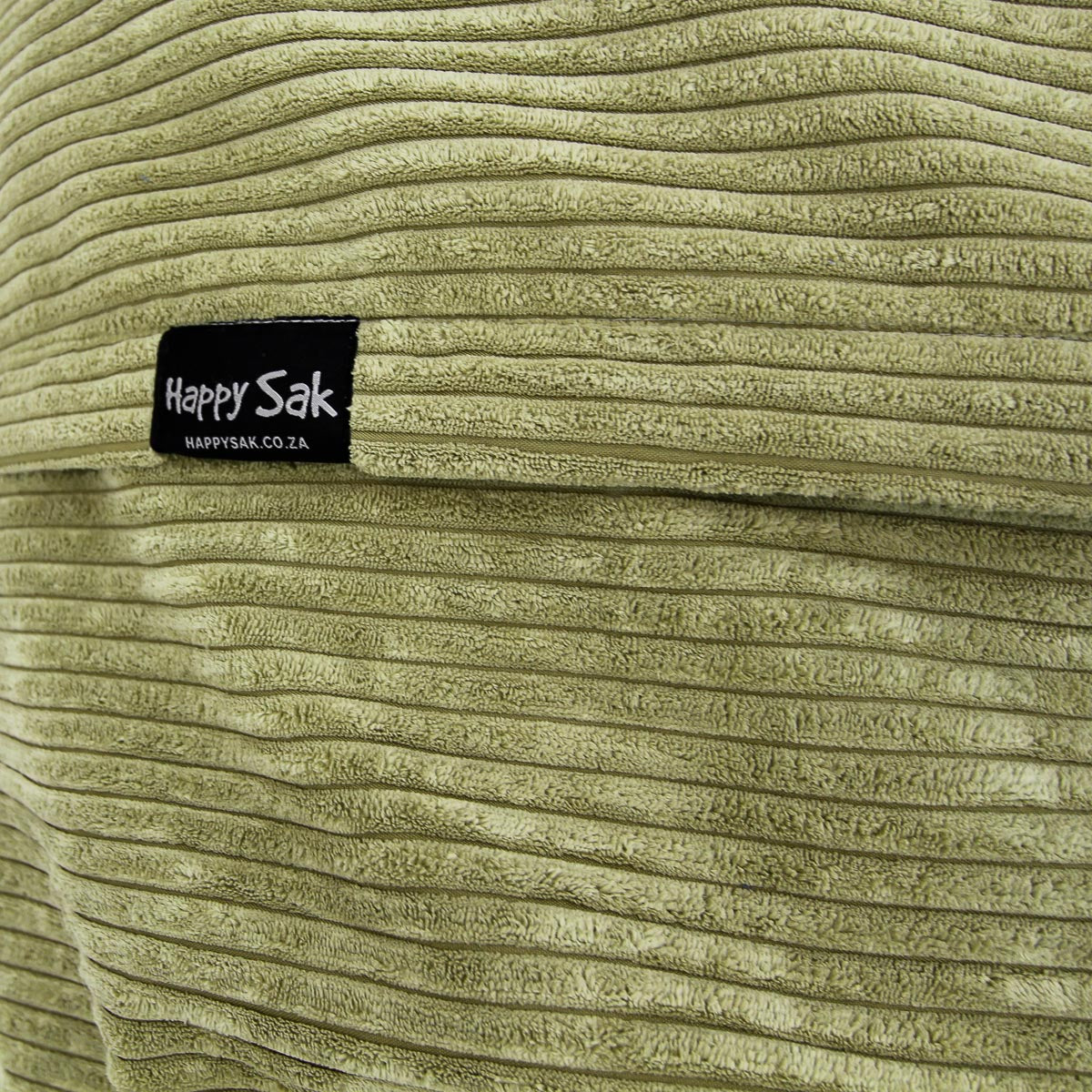 Close-up of a textured green fabric with a 'Happy Sak' label.