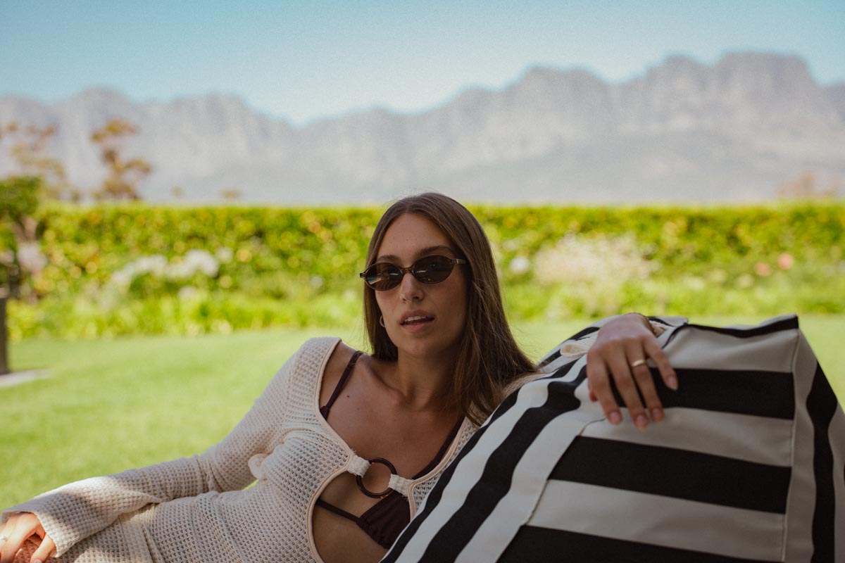 Woman sitting outdoors with mountains in the background