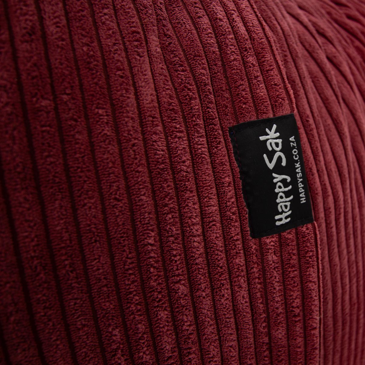 Close-up of a ribbed fabric surface with a 'Happy Sak' label.
