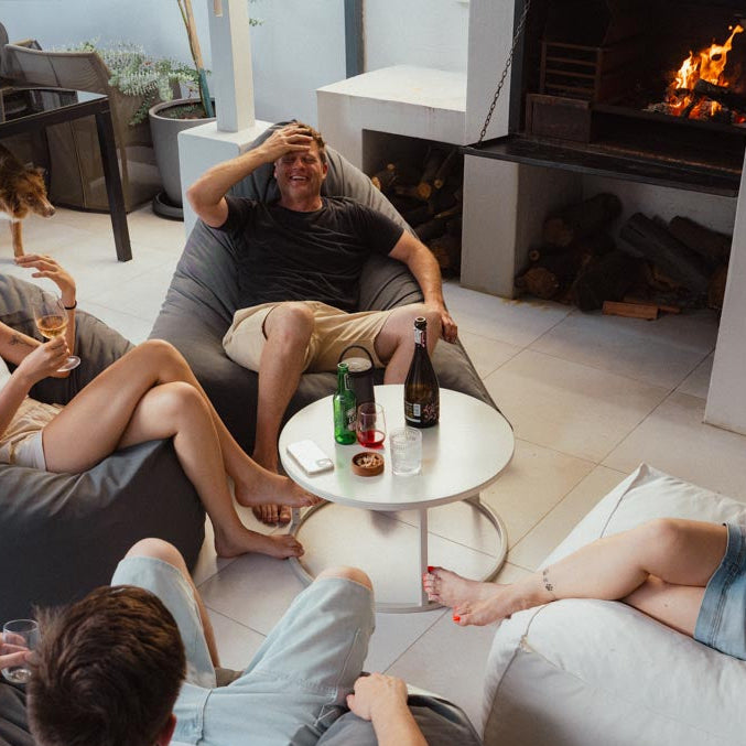 People relaxing on bean bags in a modern living room with a fireplace.