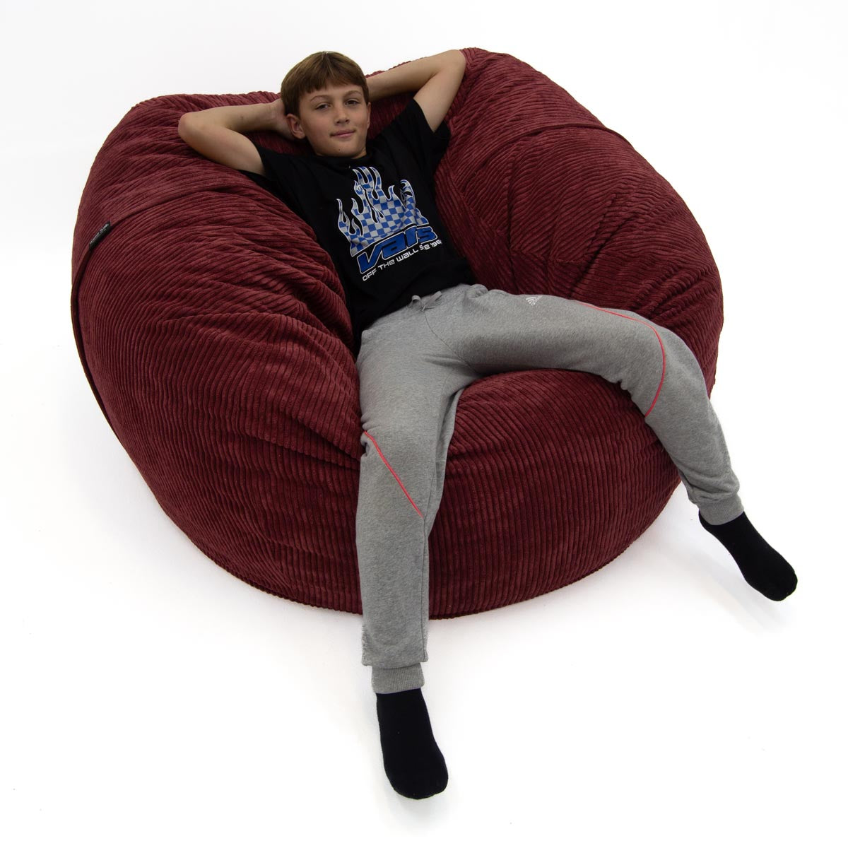 Child sitting inside a large red bean bag chair on a white background