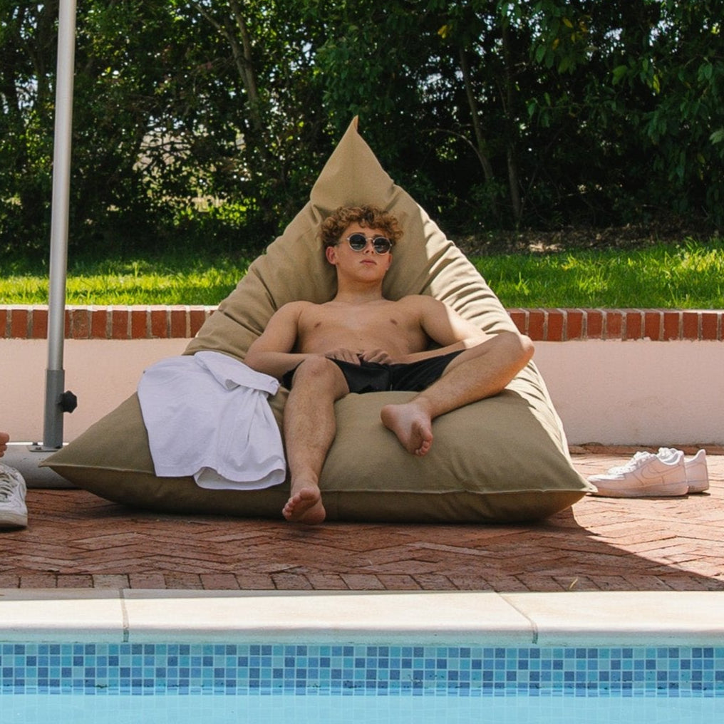 man on a beige outdoor bean bag