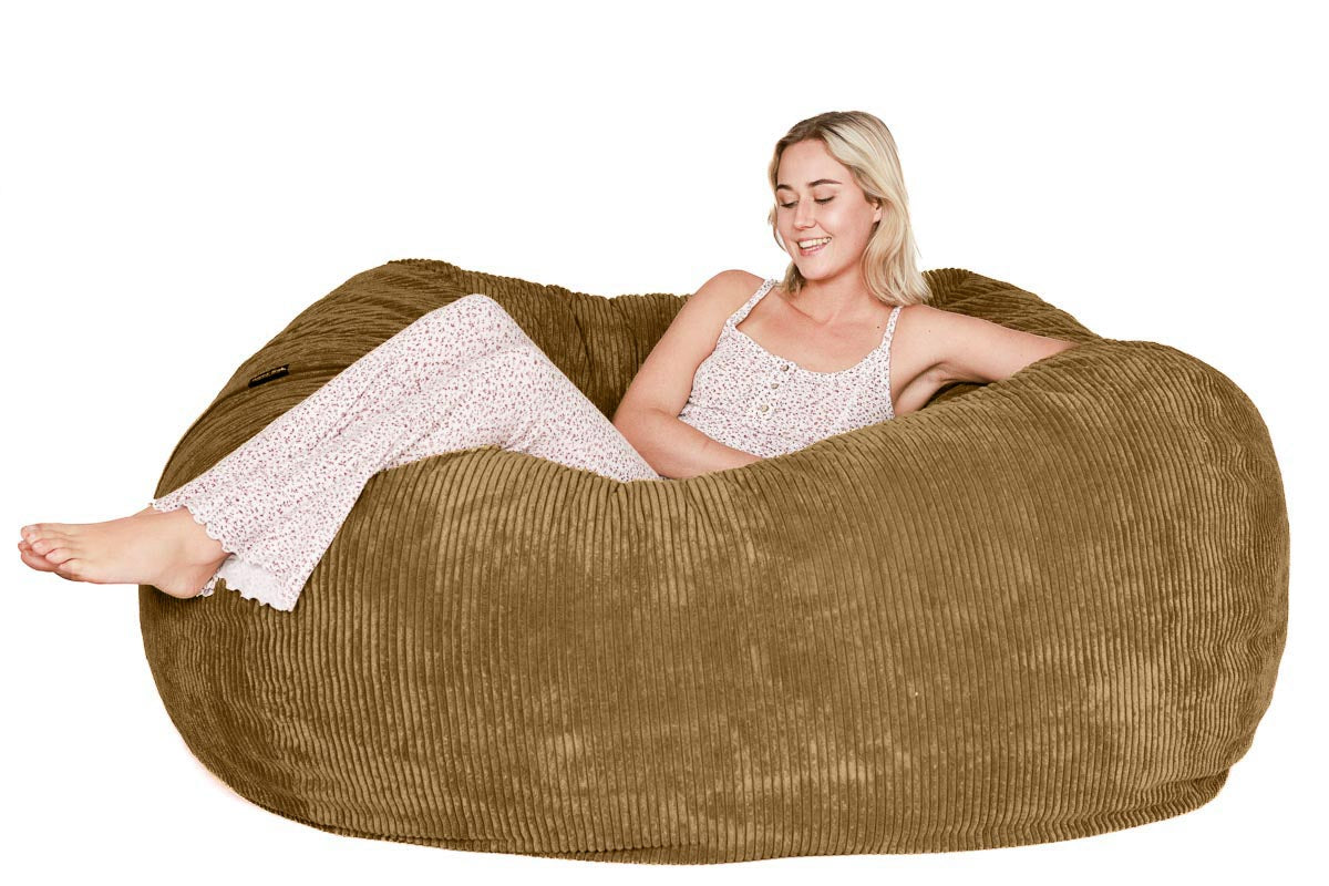 Woman sitting inside a large brown bean bag chair on a white background