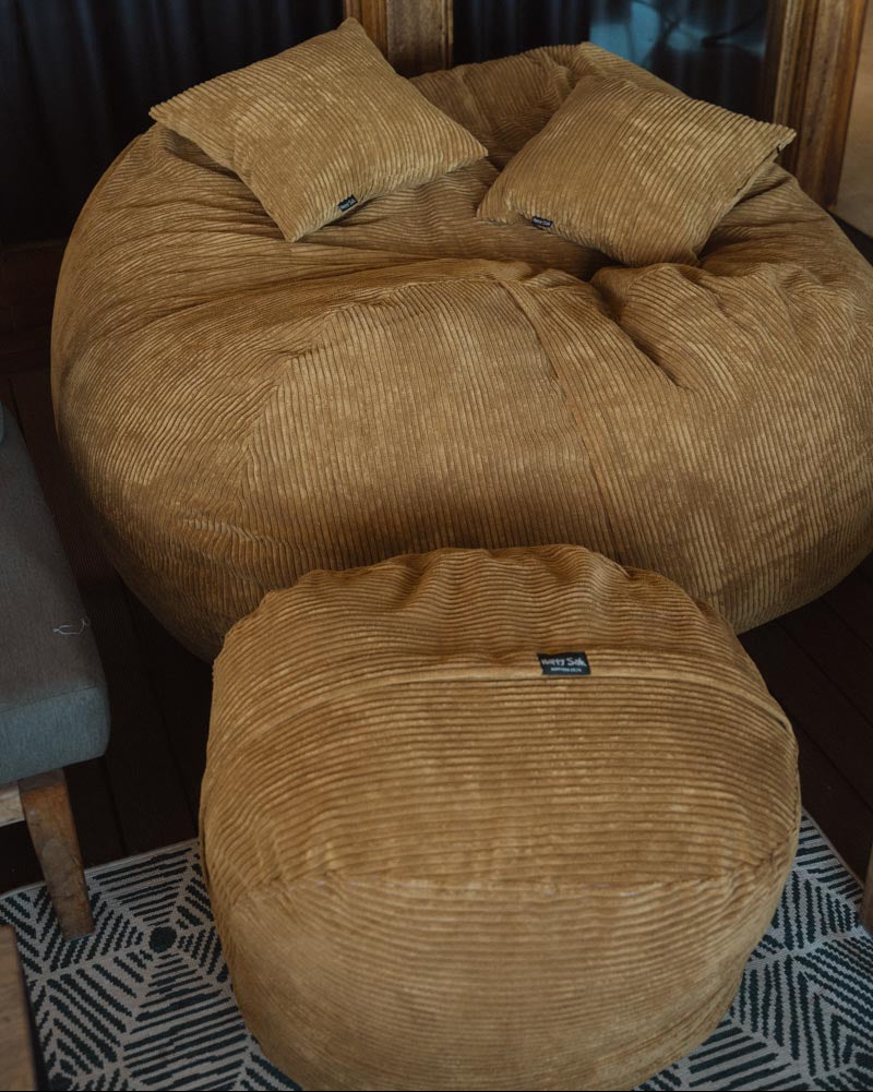 Brown textured bean bag chair with ottoman on a patterned rug