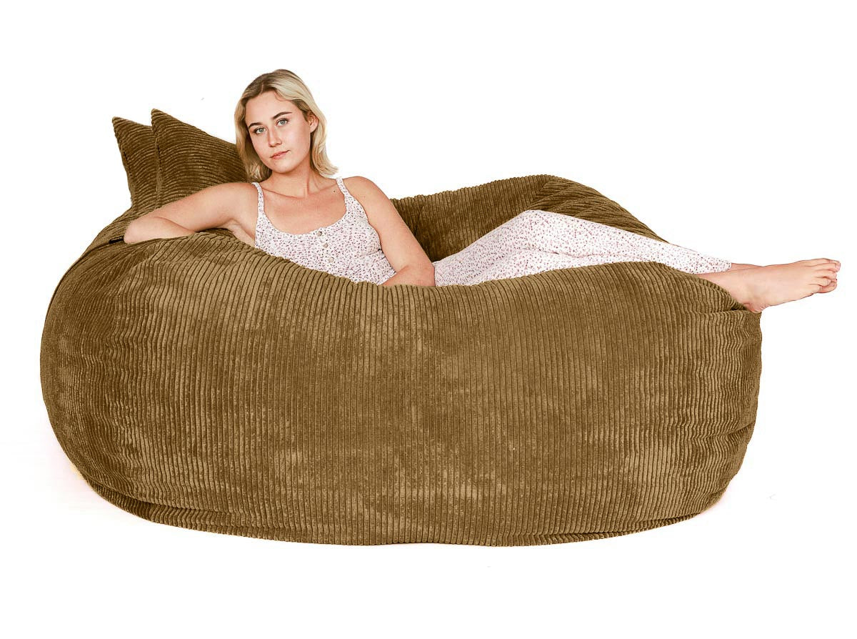 Woman sitting inside a large brown bean bag chair on a white background