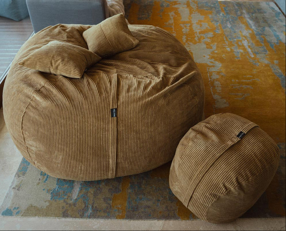 Brown bean bag chair and ottoman on a patterned rug
