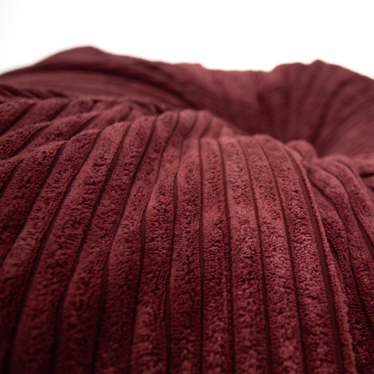 Close-up of a textured burgundy fabric with visible ribbing.