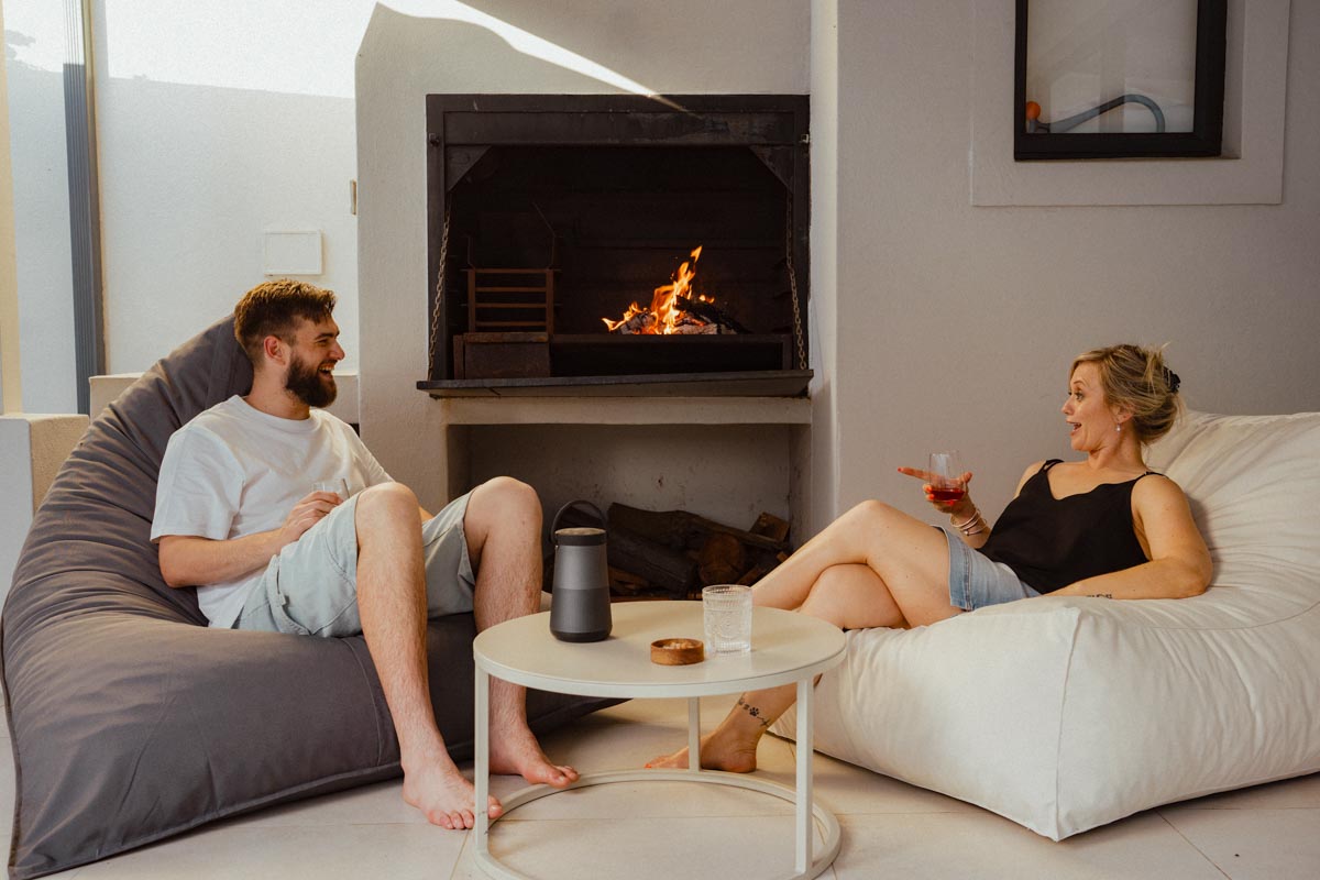 Two people sitting on bean bags in a modern living room with a fireplace.