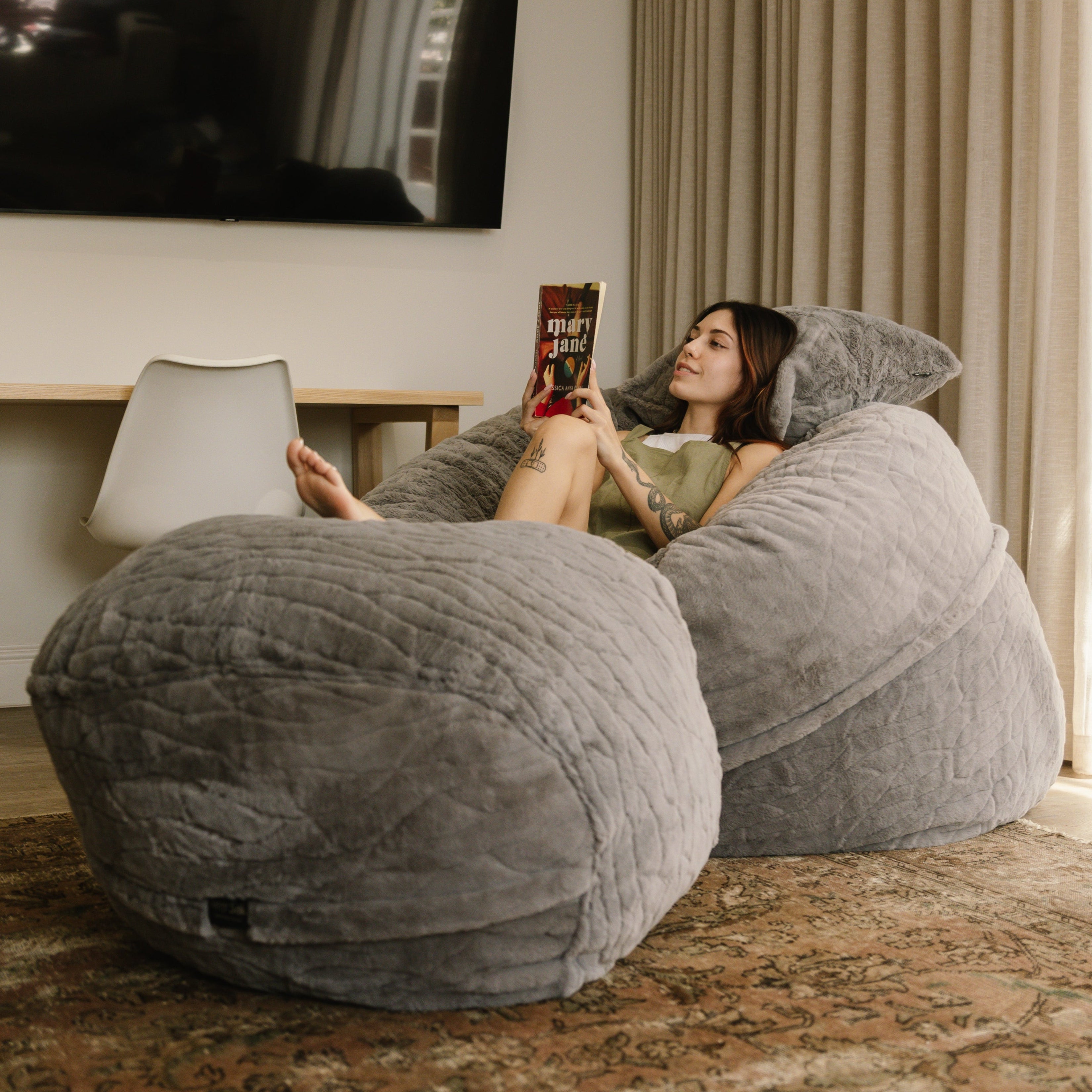 Woman reading on large faux fur beanbag