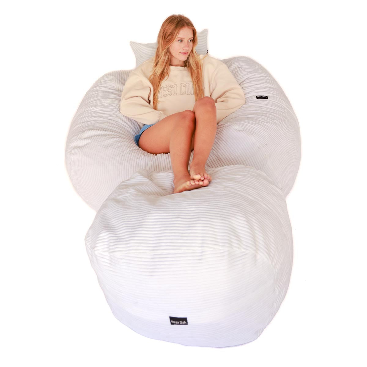 a person sitting on a white corduroy bean bag