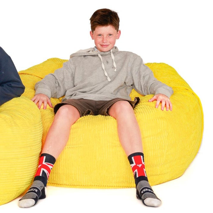 boy sitting on a yellow cord bean bag