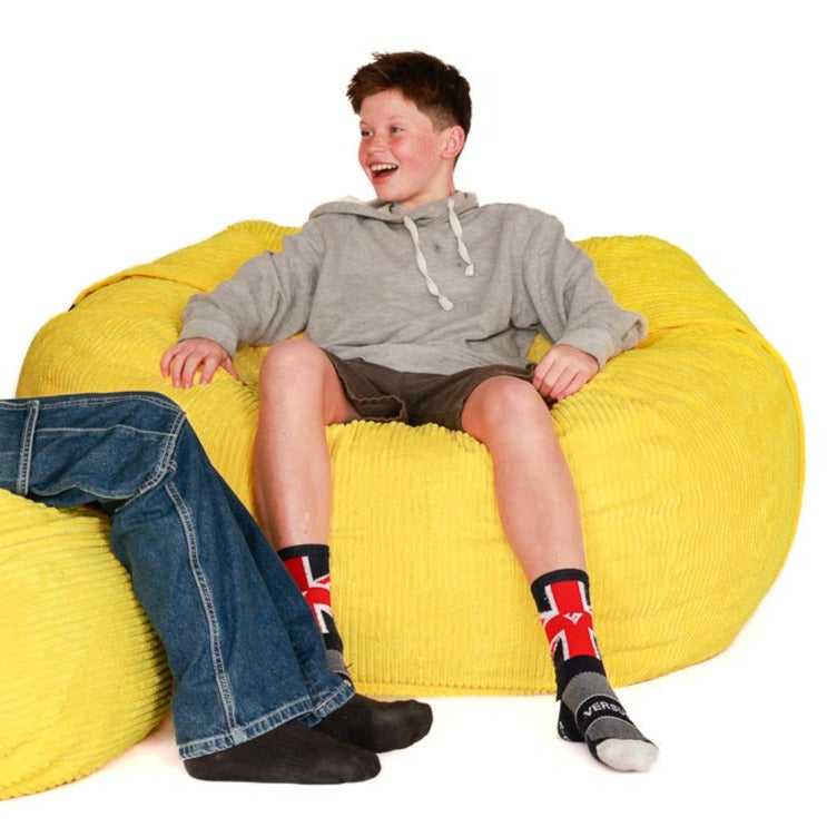 yellow bean bag with boy sitting on it
