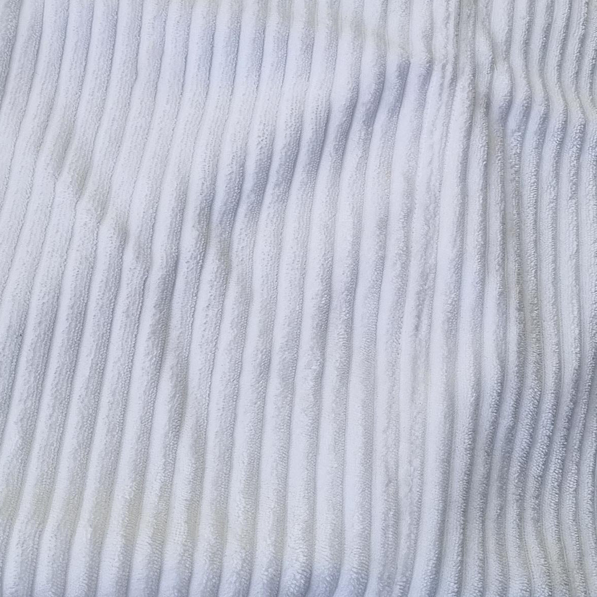 Close-up of white corduroy fabric texture.