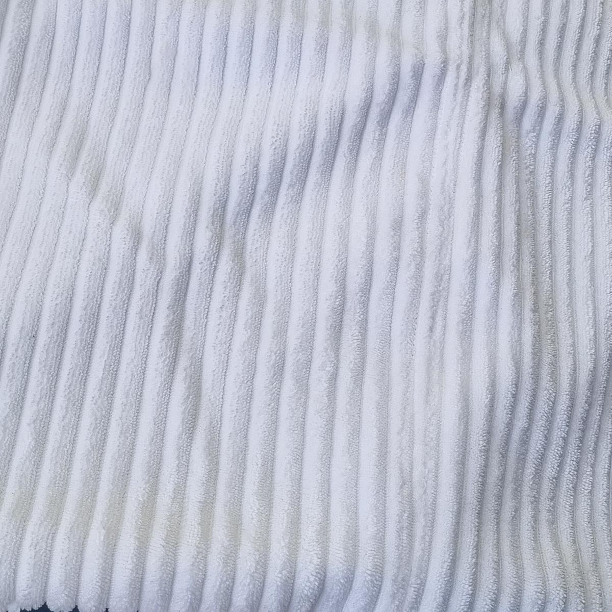 Close-up of a white corduroy fabric texture.